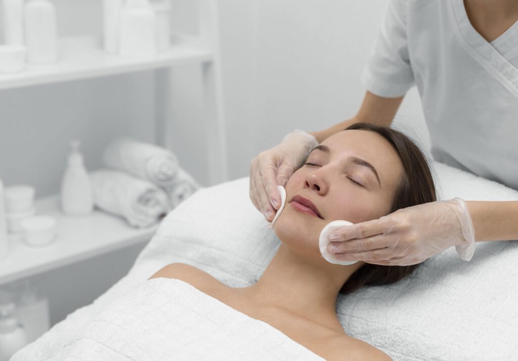 A serene image capturing a woman lying on a bed, surrounded by soft lighting, with a gentle cleanser in hand—emphasizing the soothing ritual of skincare, promoting relaxation and self-care. 