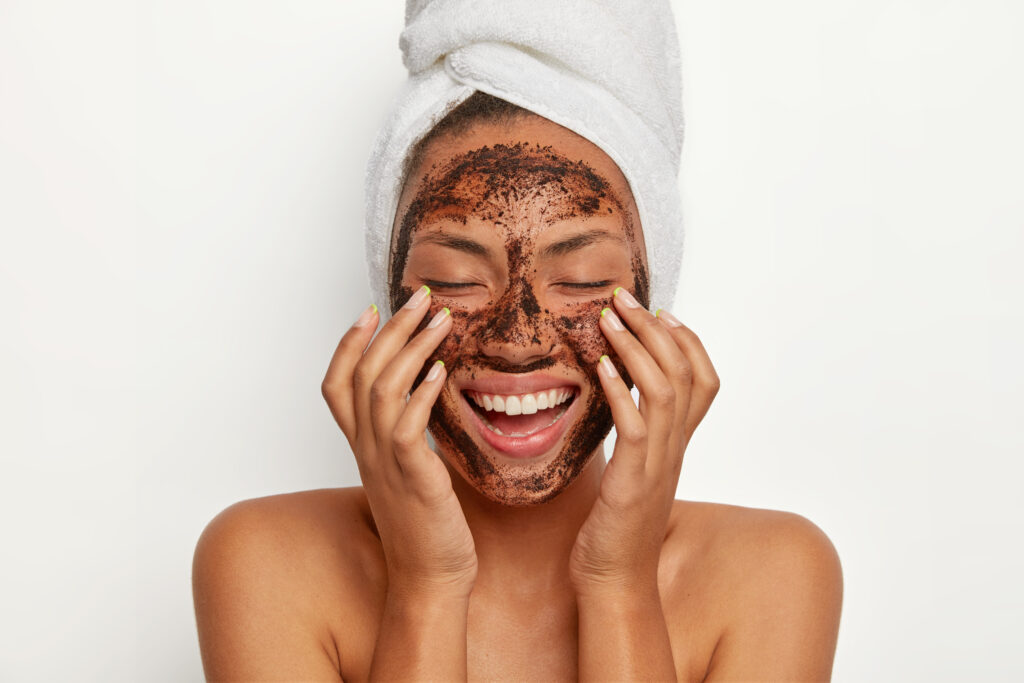 An uplifting image showcasing a woman applying an exfoliating mask, her face adorned with the product, radiating a sense of rejuvenation and self-pampering during a skincare routine.